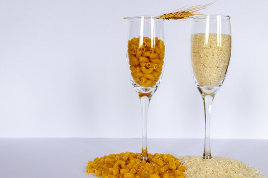Rice and wheat grains inside wine glasses , Global food security crisis concept