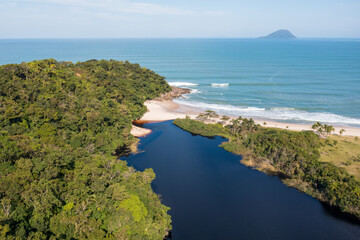 Naklejka premium Vista aérea de uma linda praia do litoral paulista com areia clara, mar, costa e um rio