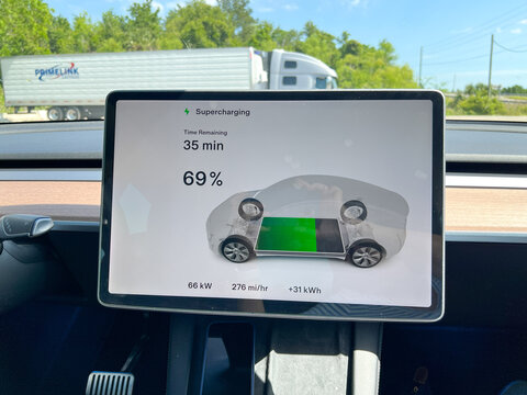 A Tesla computer screen showing that this Tesla is charging it's batteries while it is parked at a Tesla Supercharger station.