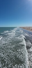 playa de arena amarilla y olas grandes