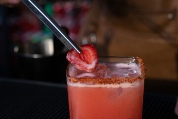 Bartender colocando fresa sobre margarita 