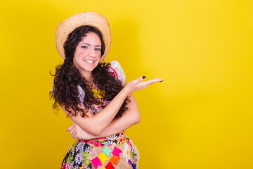 Beautiful woman dressed in typical clothes for a Festa Junina. Introducing product, space for text and advertisement.