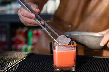 Colocando hielo en vaso de margarita 