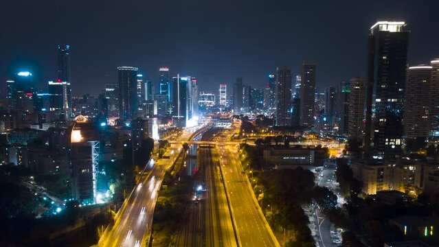 Night aerial hyperlapse of tel aviv skyline with urban skyscrapers, beautiful moving clouds, and cars on highway Israel