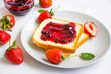 Strawberry jam in a glass of bread on an old background