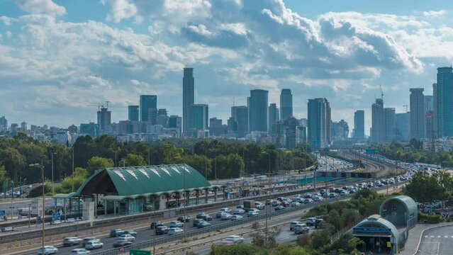 Time lapse of cars driving via ayalon road, in front of the cityscape of ramat gan and Tel Aviv cities with moving blue cloudy skies, Israel