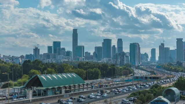 Time lapse of cars driving via ayalon road, in front of the cityscape of ramat gan and Tel Aviv cities with moving blue cloudy skies, Israel
