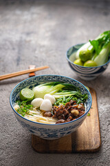 Traditional asian noodle soup with bok choi and chicken in ceramic bowl. - 507380985