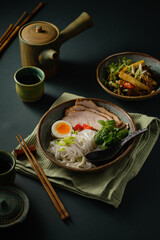 Asian noodle soup on table, ramen with pork, vegetables and egg in a bowl. Copy space - 507381100