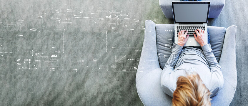 Technology screen with man using a laptop in a modern gray chair - Powered by Adobe