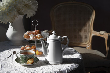 tea break in the English style, still life with flowers and donuts in the sun