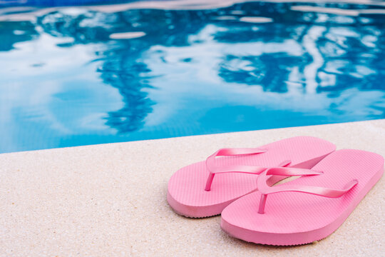 pink flip flops for swimming pool or beach. Swimming pool water texture. Pool background with summer objects. to use text.