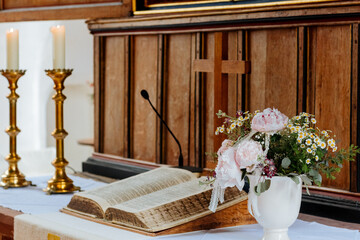 Big book in church. Altar with flowers and candles in the church. Baptism in the Church in Germany