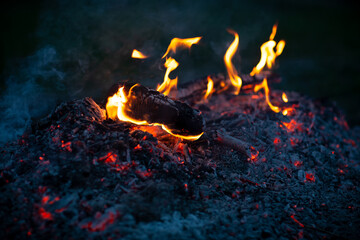 A peasant in the village made a fire from brushwood, evening of a spring day.