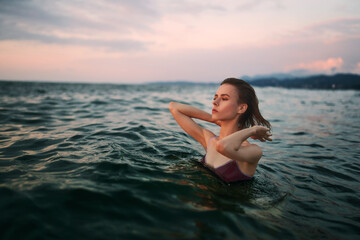Fototapeta na wymiar Pretty brunette girl is swimming in the water.