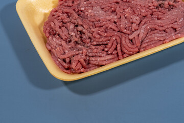 ground red meat in yellow foam board