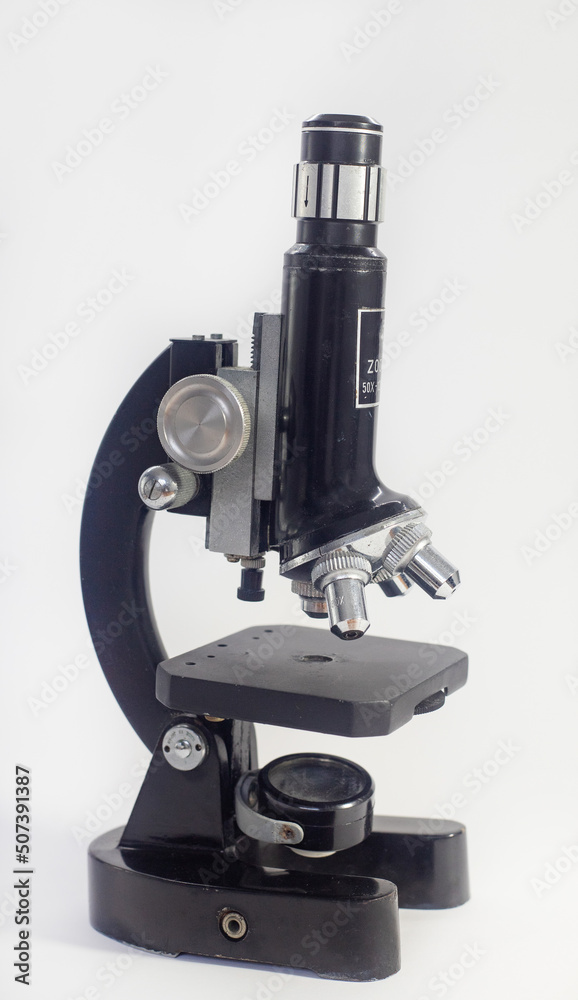 Wall mural old analog microscope, mirror on white background with copy space