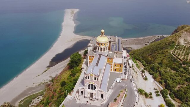 Drone aerial. Tindari Sanctuary on a cliff with views of the Aeolian Islands and the Patti gulf sea. The church hosts a statue of the black Madonna