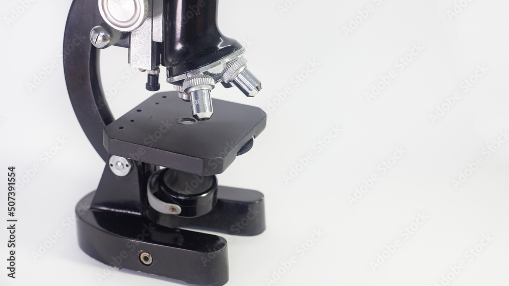 Wall mural old analog microscope, mirror on white background with copy space
