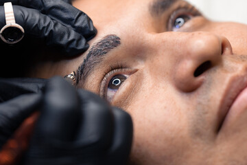 detail of micro pigmentation technique on a man's eyebrows