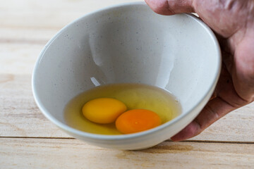 person holding a bowl of egg yolk