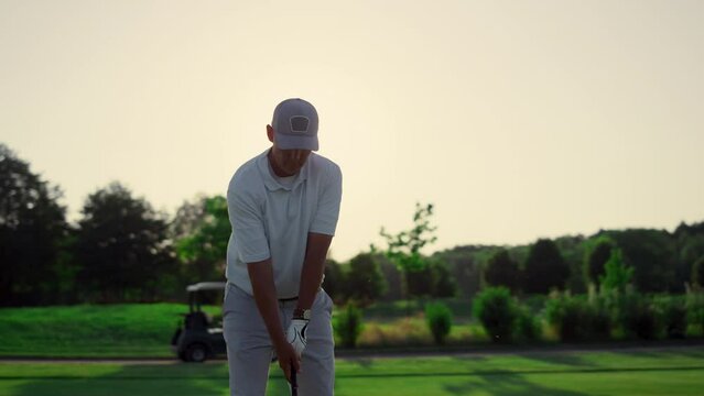 Professional golfer hitting ball on fairway game. Pensioner spend time outdoors.