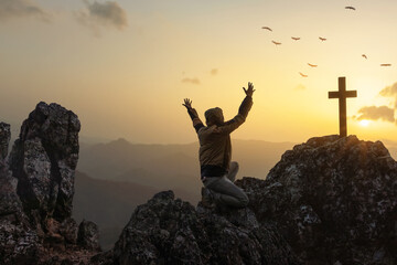 Silhouette human praying worshipping God and free bird enjoying nature on top rock mountain sunset...
