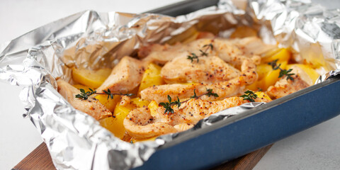 Potatoes and chicken fillets baked in foil. Easy home food