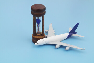 Hourglass and airplane model on blue background. Limited time for buy airplane tickets with good...