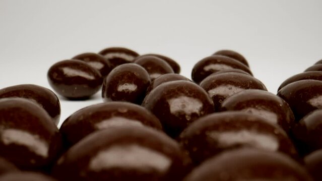 MACRO: Motion over chocolate candies on a white background, Dolly shot