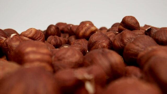 MACRO: Many Peeled hazelnuts on a white background, Dolly shot