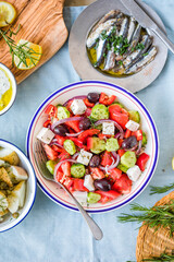 Greek food table scene, top view . Variety of items including greece salad, cucumber dip Tzatziki, Anchovy fillets, lemon potatoes.