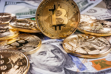 Crypto Bitcoin One dollar bitcoin, virtual money and one hundred dollar banknotes. Bitcoins on US dollars. Dollar to bitcoin exchange. Background with crypto bitcoins and dollars. Golden bitcoin. 