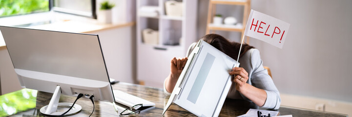 Businesswoman Covering Her Head With Laptop Asking Help