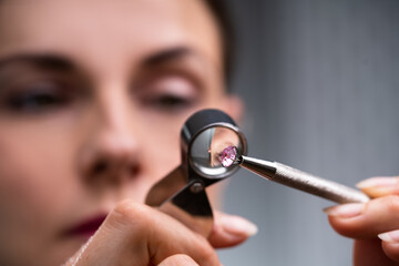Jeweler Looking At Diamond Through Magnifying Loupe