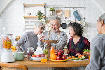 Group of Asian senior people friends making fruit juices for friends to drink in kitchen.colorful...