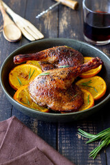 Baked duck legs with oranges and rosemary. Rustic style.