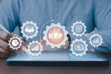 Person working on taplet to ETF Exchange traded fund stock market trading investment financial...