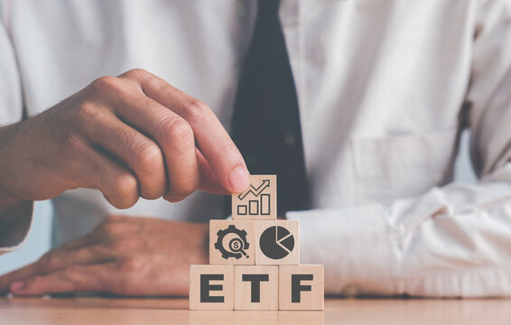 Investor holds the wooden cube with bitcoin icon standing with "ETF" text. Entering the digital money fund. ETF (Exchange Traded Fund), business/finance conceptual..