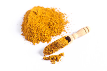Pile of curry powder in a wooden spoon isolated on white background. Spices and herbs. Close-up, top view.