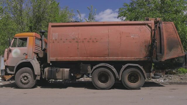 an old garbage truck collects garbage