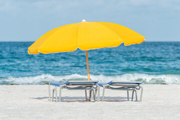 Yellow umbrella and lounge chairs on the beach