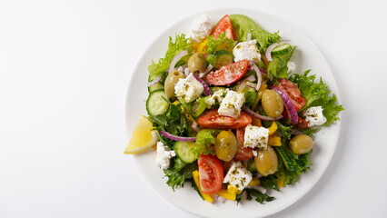 Greek salad. Fresh vegetable salad with tomato, onion, cucumbers, sweet pepper, olives, olive oil, lettuce, red onion, and feta cheese.