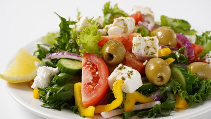 Greek salad. Fresh vegetable salad with tomato, onion, cucumbers, sweet pepper, olives, olive oil, lettuce, red onion, and feta cheese.