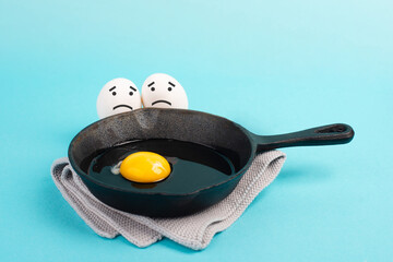 A fried egg in a pan, two friends look with sad faces at him, having a breakfast in the morning,...