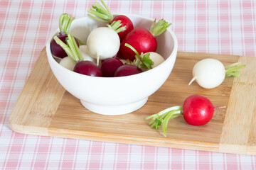 tricolor radishes in a bowl on a table