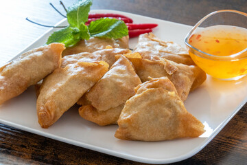 samosa on a plate with sweet and sour sauce