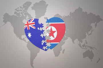 puzzle heart with the national flag of north korea and australia on a world map background. Concept.