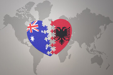puzzle heart with the national flag of albania and australia on a world map background. Concept.
