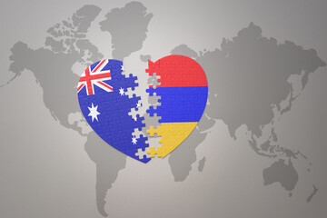 puzzle heart with the national flag of armenia and australia on a world map background. Concept.